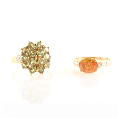 Lot 253 - An orange solitaire ring with diamond shoulders, and a green and white stone cluster ring.