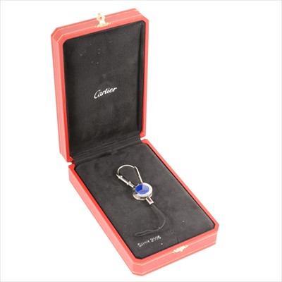Lot 703 - Cartier - a steel key ring with blue crown centre and watch bezel frame.