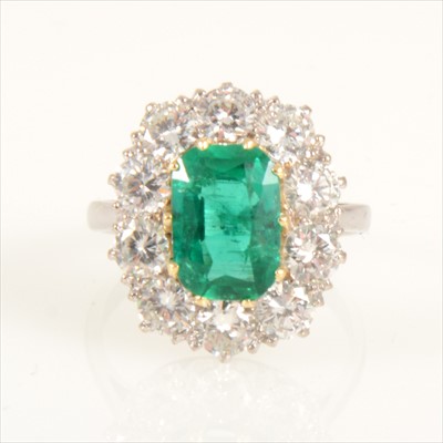 Lot 676 - An emerald and diamond cluster ring.