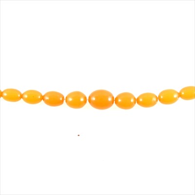 Lot 469 - A string of twenty-seven amber coloured egg shaped beads