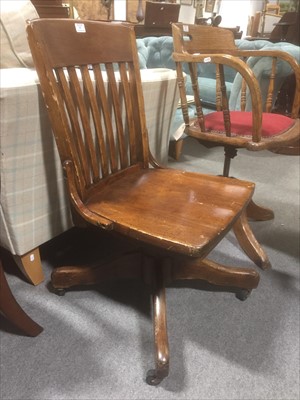 Lot 557 - A stained wood swivel office chair