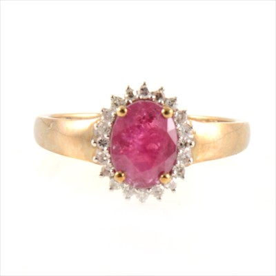 Lot 443 - A ruby and diamond oval cluster ring.