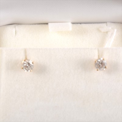 Lot 449 - A pair of diamond solitaire earrings.