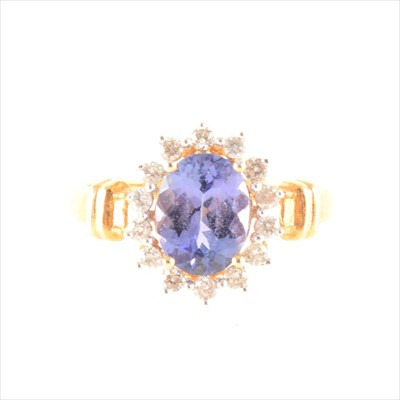 Lot 198 - An oval tanzanite and diamond cluster ring.