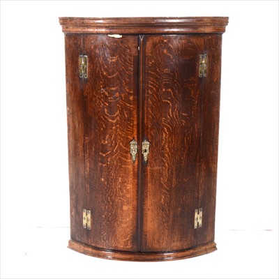 Lot 392 - A George III oak cylinder front hanging corner cupboard