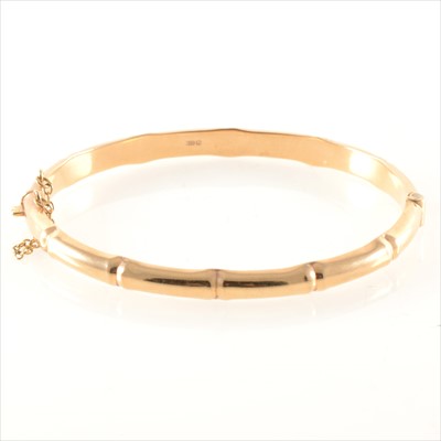 Lot 284 - A 9 carat yellow gold hollow half hinged bamboo design bangle.