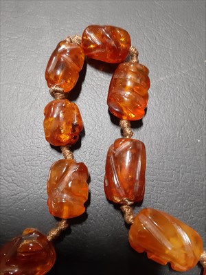 Lot 302 - An amber coloured bead necklace.