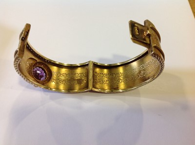 Lot 94 - A late 19th Century yellow metal bangle with an amethyst, diamond and pearl cluster.