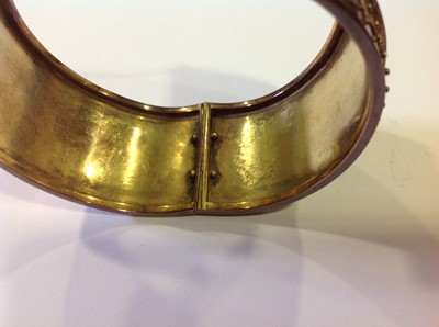 Lot 95 - A mid 19th Century yellow metal 33mm wide half hinged bangle