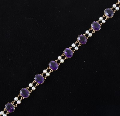 Lot 1306 - An amethyst and pearl bracelet, strung with ten oval cut stones