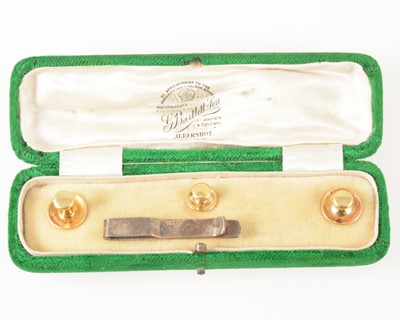 Lot 1356A - A cased set of three dress studs marked 18ct. and a silver tie slide.