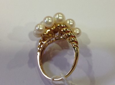 Lot 35 - Mikimoto -  an 18 carat yellow gold dress ring set with seven graduated small diamond and pearls.