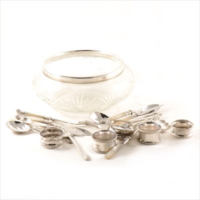 Lot 266 - A glass fruit bowl with silver rim, silver and plated napkin rings and assorted flatware.