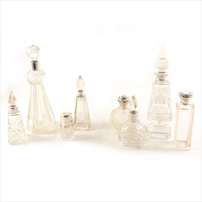 Lot 223 - Eight silver-topped glass perfume / liqueur bottles.