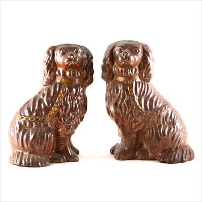 Lot 65 - A pair of treacle glazed stoneware models of seated Spaniels, North Midlands, mid-19th Century