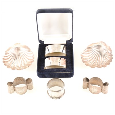 Lot 244 - Five silver napkin rings and a pair of shell dishes.