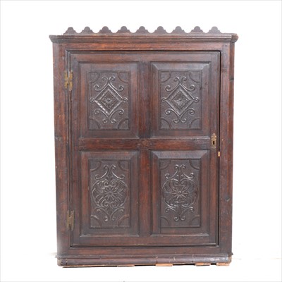 Lot 252 - A carved oak hanging corner cupboard