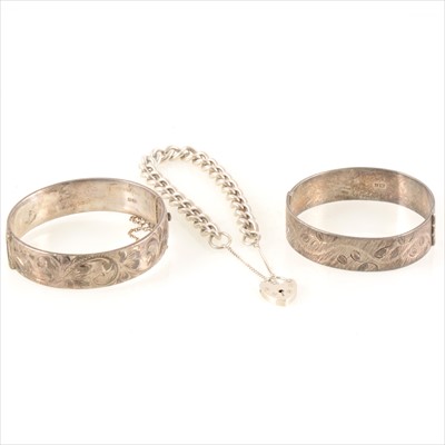 Lot 1341 - Two silver bangles and a silver curb link bracelet.