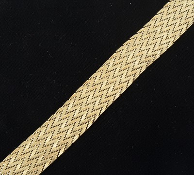 Lot 1302 - An 18 carat yellow gold 20mm wide flexible herringbone design bracelet.