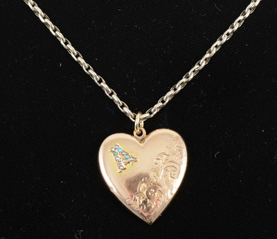 Lot 1328 - A 9 carat rose gold heart shaped locket and yellow metal chain.