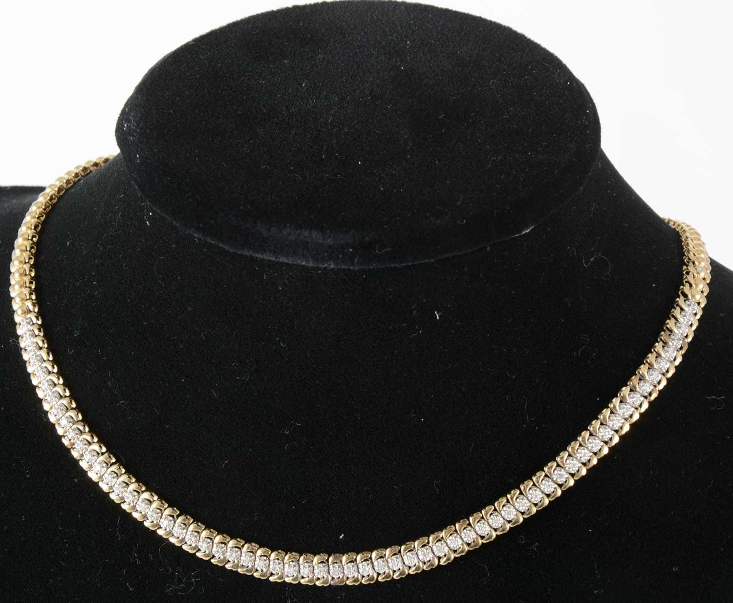 Lot 107 - A 9 carat yellow and white gold collar necklace set with small diamonds.