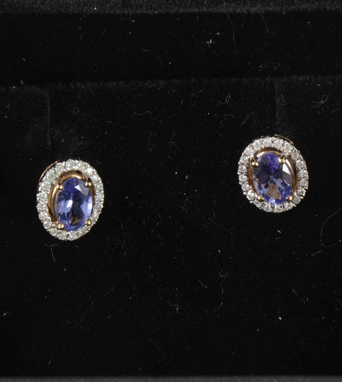 Lot 55 - A pair of tanzanite and diamond earstuds.