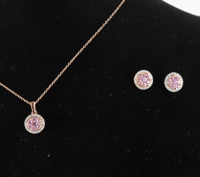 Lot 122 - A pink sapphire and diamond pendant and matching earstuds.