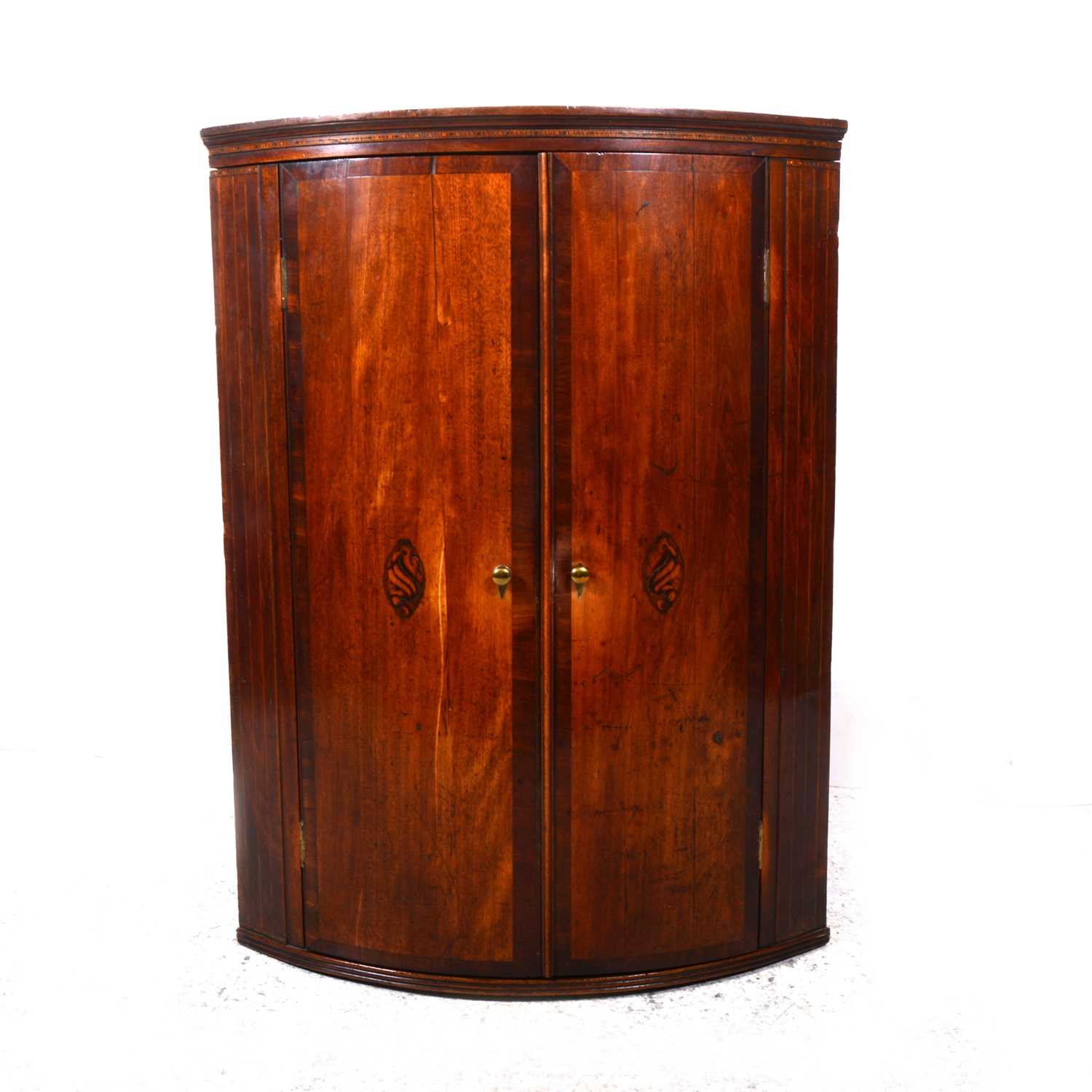 Lot 18 - A George III oak and mahogany cylinder front hanging corner cupboard
