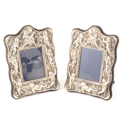 Lot 179 - Two modern silver repousse chased photograph frames decorated with cherubs.