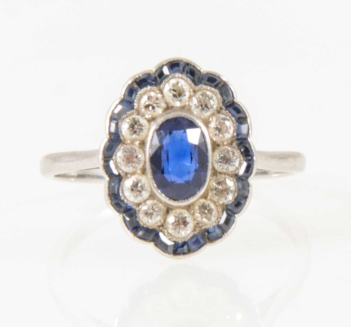 Lot 19 - A sapphire and diamond oval cluster ring in the Art Deco style.
