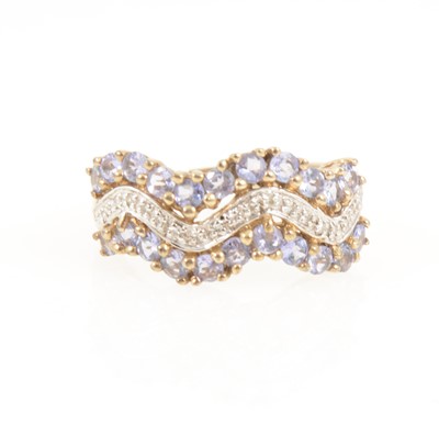 Lot 1264 - A tanzanite and diamond three row wave dress ring.