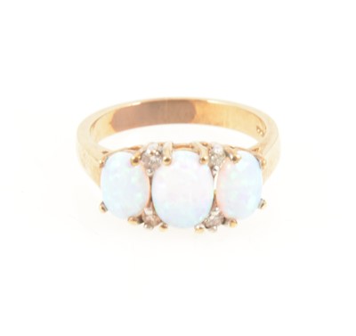 Lot 1266 - An opal three stone ring.