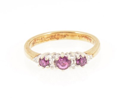 Lot 1261 - A ruby and diamond half hoop ring.