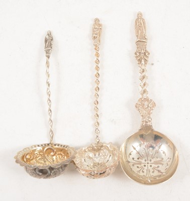 Lot 1210 - Three silver sugar sifting spoons with Apostle finials.