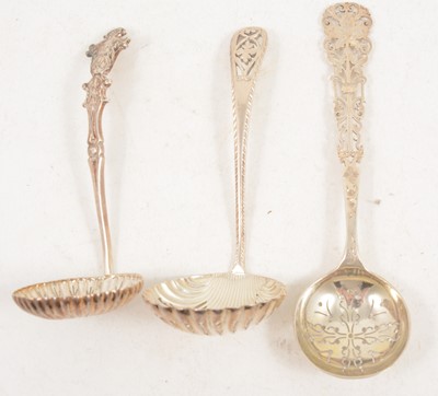 Lot 1202 - Three ornate silver sugar sifting spoons, Sheffield.