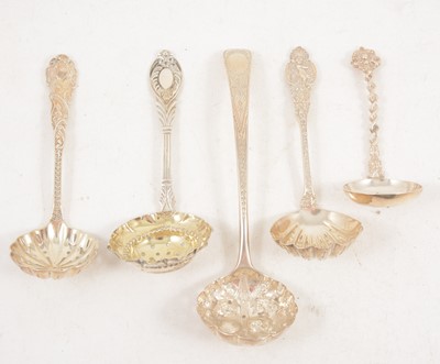 Lot 1203 - Five ornate silver sugar sifting spoons, London.