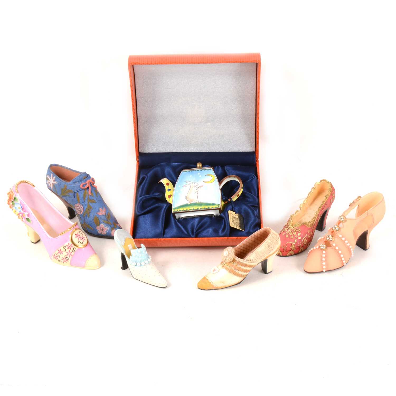 Lot 1016 - A collection of miniature decorative shoes, miniatyre enamelled teapot, and household linen