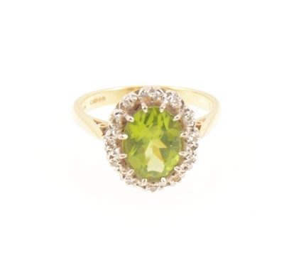 Lot 1270 - A peridot and diamond oval cluster ring.