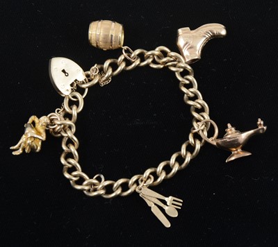 Lot 1310 - A 9 carat yellow gold solid curb link charm bracelet.