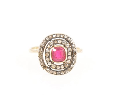 Lot 353 - A diamond ring with ruby coloured stone to centre