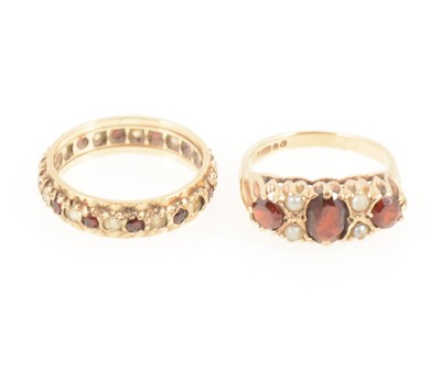 Lot 1274 - A garnet and pearl ring and a garnet eternity ring.