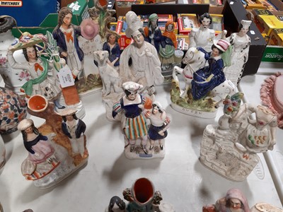 Lot 1054 - Fourteen Staffordshire figures and spill vases