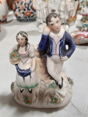 Lot 1054 - Fourteen Staffordshire figures and spill vases