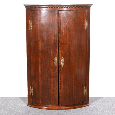 Lot 501 - A Georgian stained oak cylinder front hanging corner cupboard