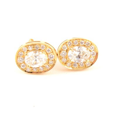 Lot 100 - A pair of oval diamond cluster earrings.