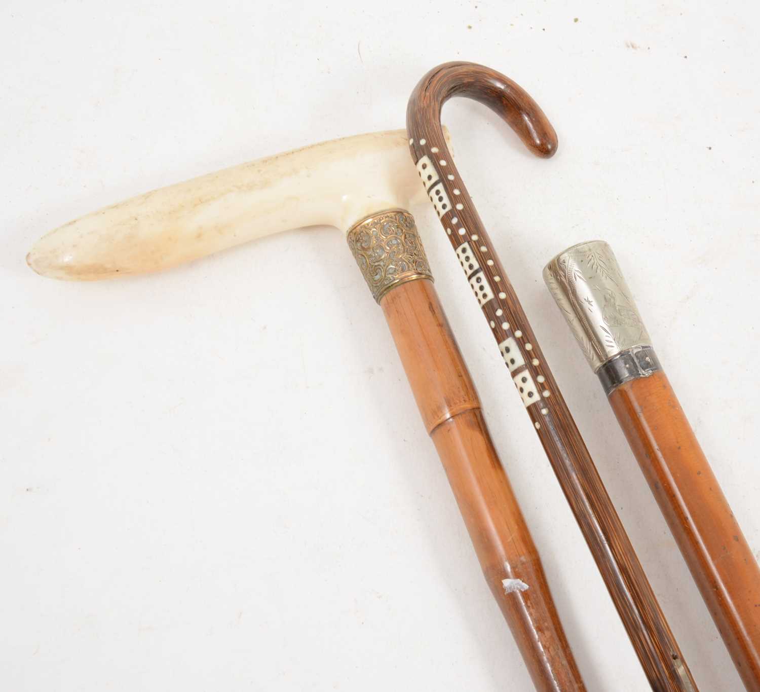 Lot 1150 - A horn cane inset with miniature ivory dominoes, and two other canes