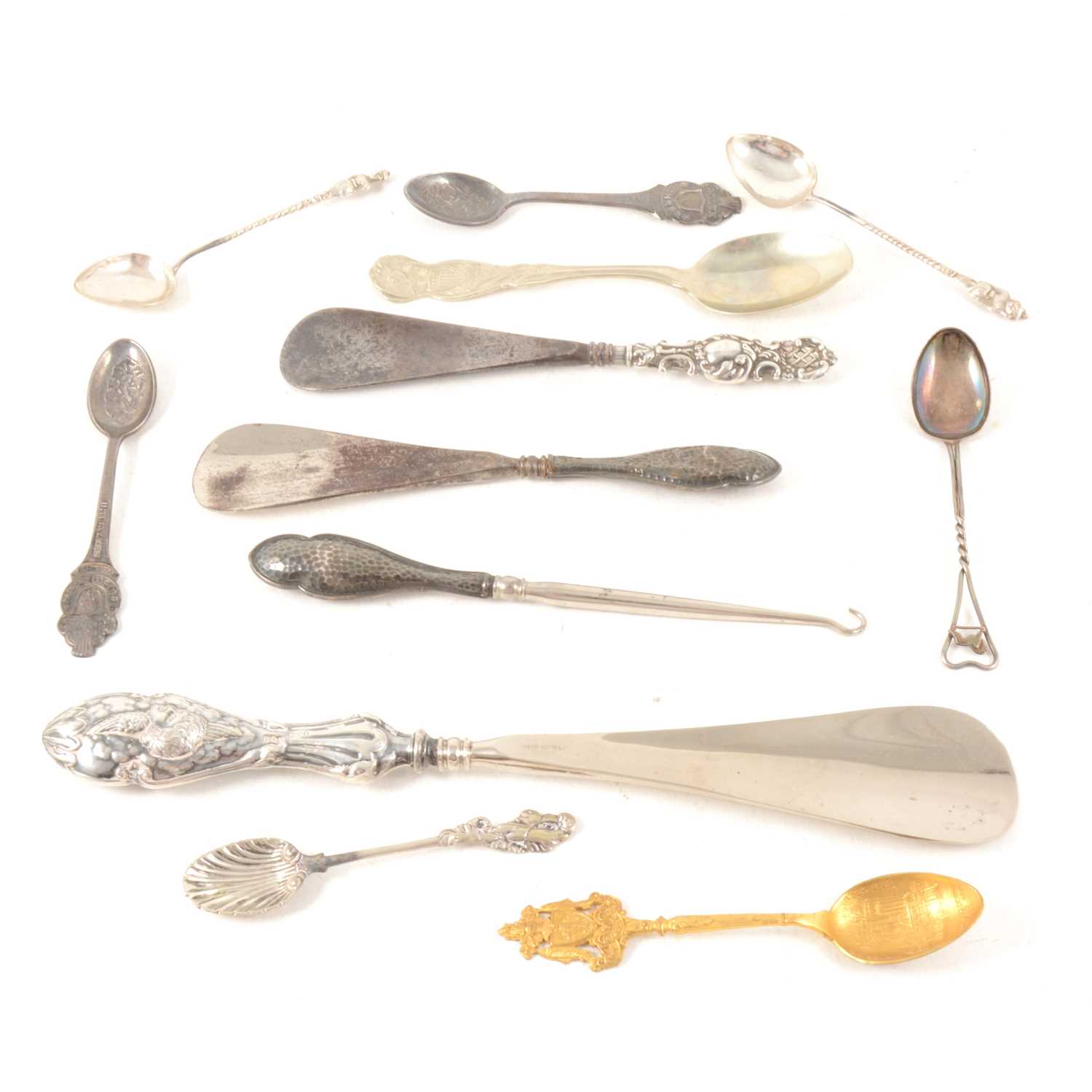 Lot 111 - Three silver handled shoehorn and a buttonhook together with Scottish, American and Eastern teaspoons and two Rolex Watch Interlaken teaspoons.