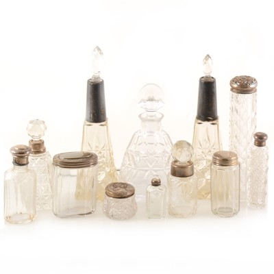 Lot 288 - A small collection of silver-topped scent bottles and other dressing table jars.