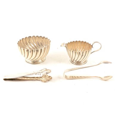 Lot 333 - A silver milk jug and sugar bowl, plus two pairs of silver-plated sugar tongs.