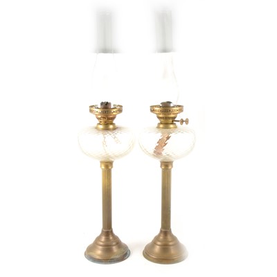 Lot 214 - Pair of brass oil lamps with clear glass reservoirs